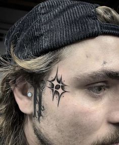 a man with a tattoo on his face has a cross and compass tattooed on his forehead