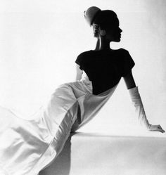 a black and white photo of a woman sitting on a ledge