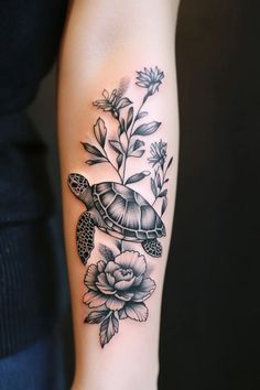 a woman's arm with a turtle and flowers on it