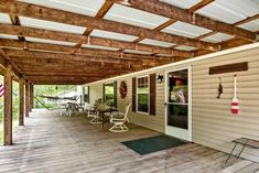 a covered porch with chairs and an american flag hanging on the wall next to it