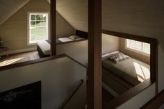 an attic bedroom with two windows and a bed in the corner on the second floor