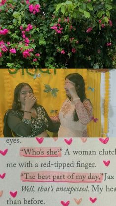 two women standing next to each other in front of flowers