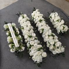 white flowers laid out on the ground next to each other with candles in front of them