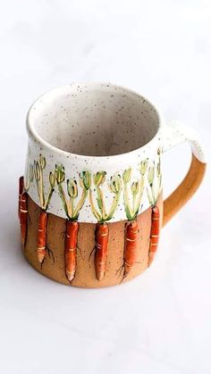 a ceramic mug with carrots painted on it