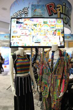 two mannequins dressed in colorful clothing stand next to a sign that says rainbow's rain