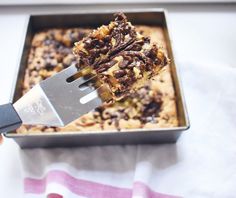 a person holding a spatula over a piece of cake