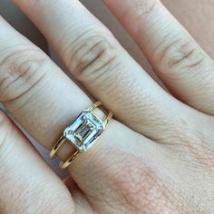 a woman's hand with a diamond ring on top of her finger and an engagement band