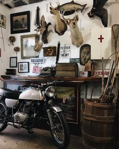 a motorcycle parked in front of a wall with deer heads on it