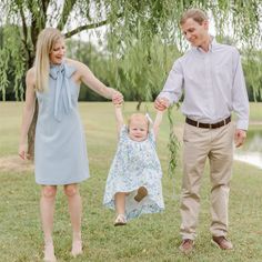 a man and woman holding hands with a baby