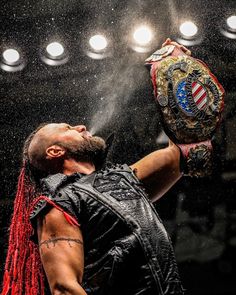 a man with dreadlocks holding up a boxing glove