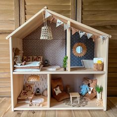 a wooden doll house with furniture and decorations