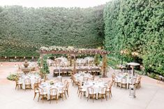 an outdoor dining area with tables and chairs set up for a wedding reception in the middle of trees