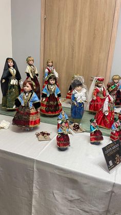 a table topped with lots of figurines sitting on top of a white table cloth