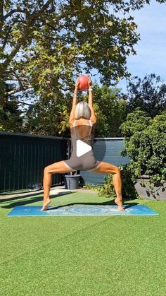 a woman is doing yoga outside with a ball