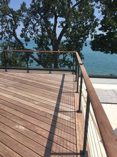 a wooden deck overlooking the water and trees