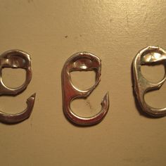 three fish hooks from can tabs hanging on a wall with the words diy