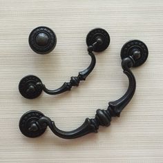 a black door handle on a white wall with two knobs in the shape of a smiley face