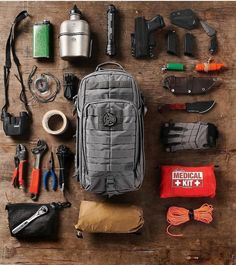 the contents of a backpack laid out on a wooden table with tools and gadgets