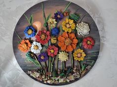 there are many different flowers on this circular wall decoration that is made out of wood