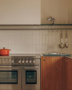 a stove top oven sitting inside of a kitchen next to a wooden cabinet and counter