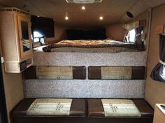 the inside of a camper with two beds and couches