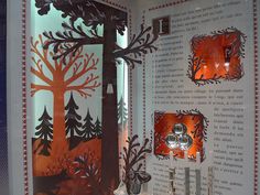 an open book with paper cut trees on it