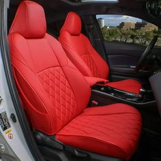 the interior of a white car with red leather seats and steering wheel covers on it