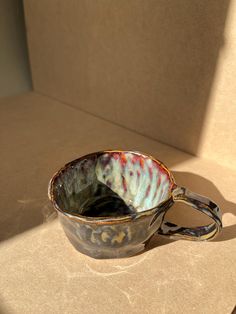 a cup sitting on top of a counter next to a box filled with something else