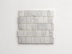 a white marble mosaic tile on the wall