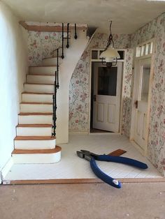 a pair of scissors laying on the floor in front of a staircase leading up to an open door