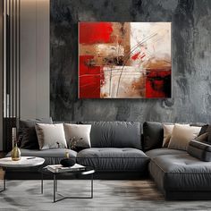 a modern living room with grey couches and red painting on the wall above it