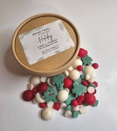 a wooden box filled with lots of different colored candies on top of a white table