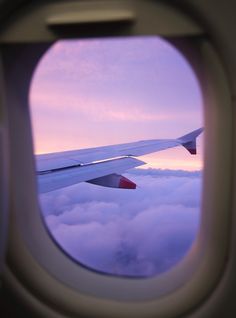 an airplane window looking out at the clouds