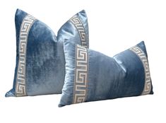 two blue velvet pillows with greek motif on the sides, one in grey and white