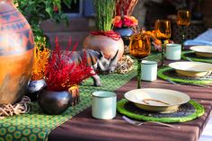 the table is set with plates, cups and vases