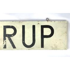 an old rusted sign that says rup hanging on a wall with the word rup written in black