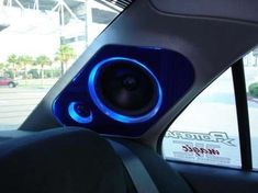 the interior of a car with blue lights and speakers on it's dash board