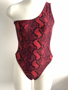 a mannequin wearing a red and black snake skin print swimsuit with one shoulder