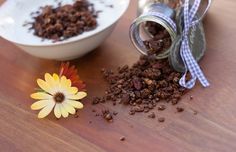 a wooden table topped with a bowl of food and a jar filled with granola