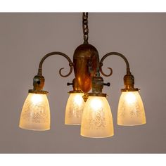 three light chandelier with frosted glass shades hanging from it's ceiling