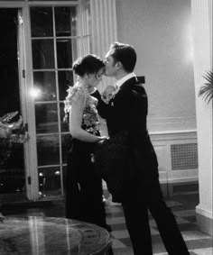 a man and woman in formal wear kissing each other