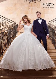 a man and woman in formal wear standing on stairs