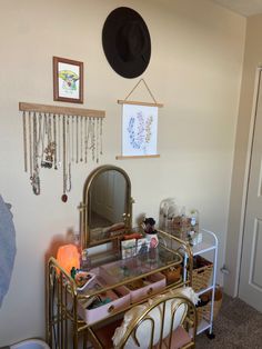 a gold vanity with a mirror and jewelry on it in a room next to a door