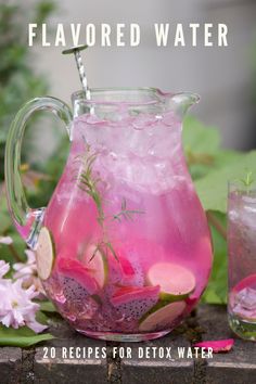 a pitcher filled with pink liquid next to flowers