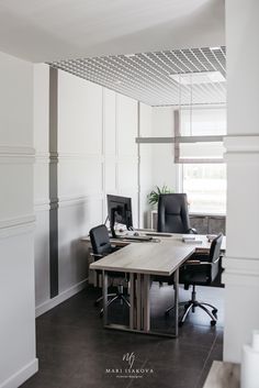 an office with two black chairs and a wooden table