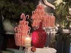 candy canes are stacked on top of each other in front of a christmas tree