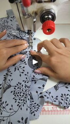 two hands are using a sewing machine to sew fabric