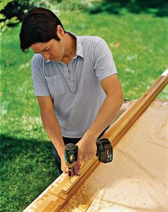 a man sanding wood with a power drill