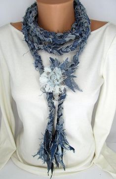 a woman wearing a white shirt and blue scarf with flowers on it's neck