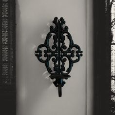 a black clock mounted to the side of a wall